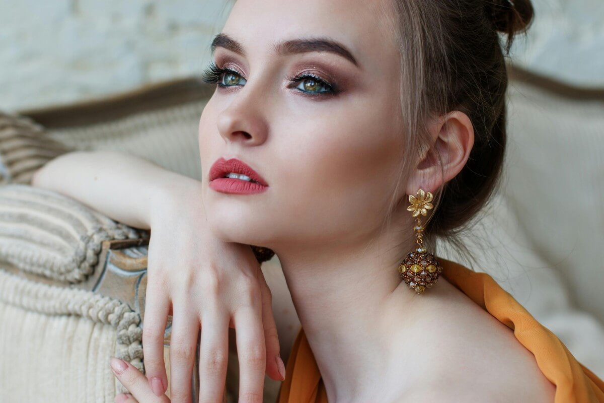 Chica portando unos pendientes y joyas de lujo